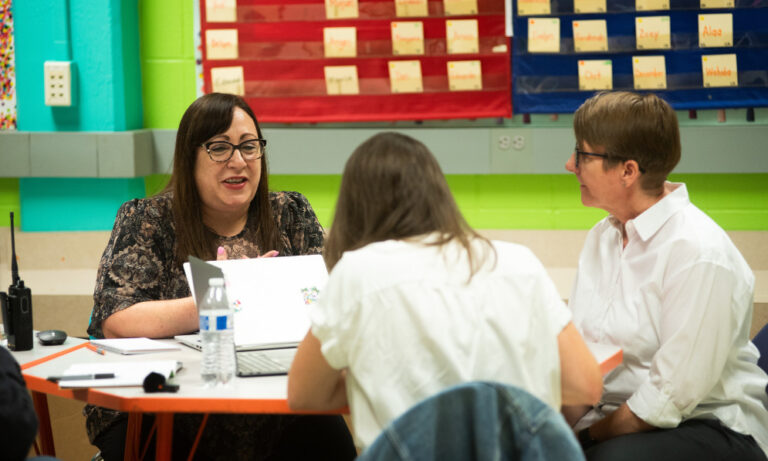 Gladstone leaders and Instruction Partners team collaborate around a table